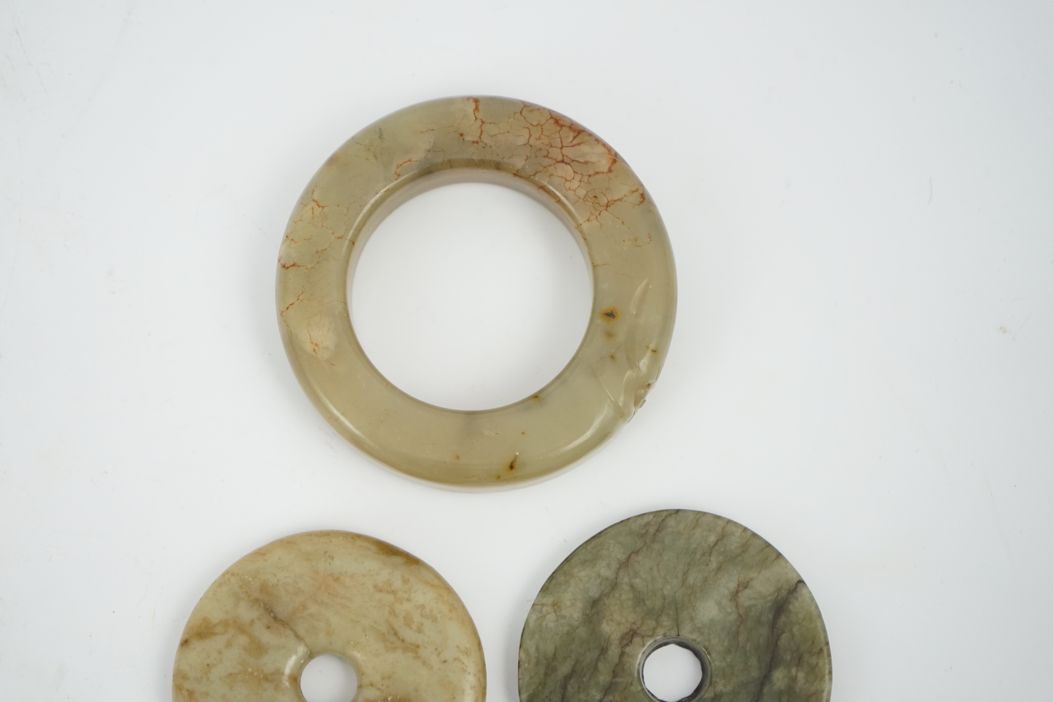 Two Chinese soapstone bi discs, and a jade ring, 18th century or earlier, largest 6.5cm in diameter. Condition - good